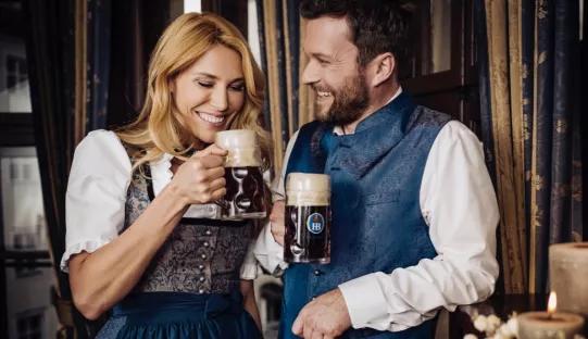 Pärchen in Tracht mit Krügen mit dem Saisonbier Winterzwickl