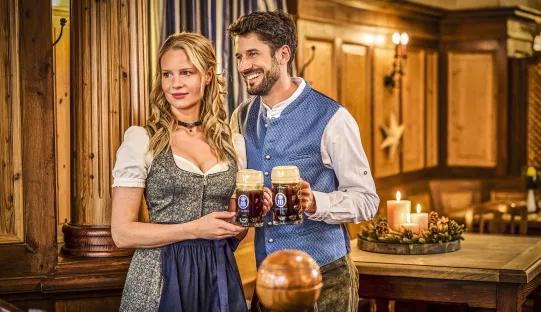 Pärchen in Tracht mit Krügen mit Saisonbier Winterzwickl