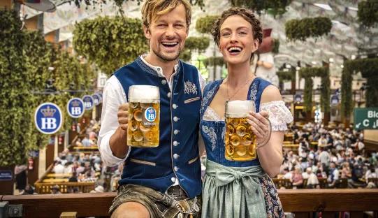 couple with oktoberfest beers in hofbräu tent