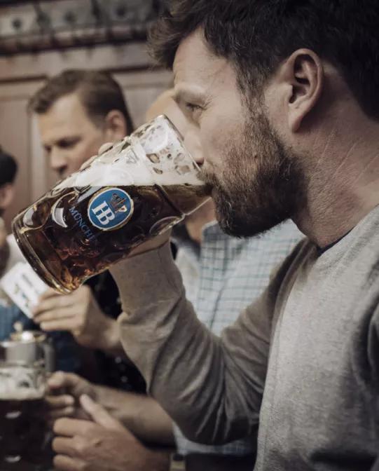 Hofbräu Dunkel Bier im Masskrug beim Stammtisch mit Kartenspiel