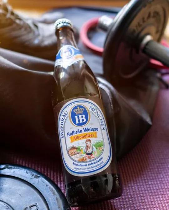 Weisse Alkoholfrei Weissbierflasche mit Sportzubehör für sportlichen alkoholfreien Biergenuss