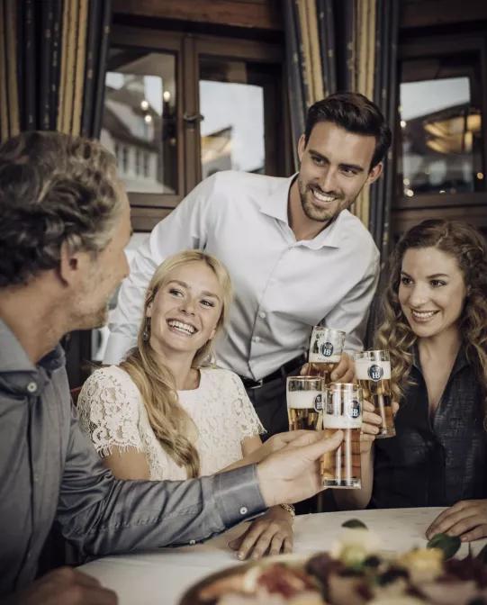 Hofbräu Original Freundesgruppe mit Biergläsern anprosten