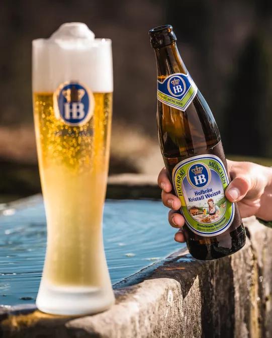 Kristall Weisse Weissbier im Glas mit Schaumkrone und Flasche