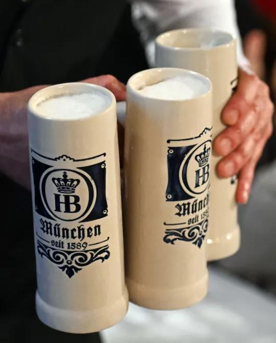 Maibock Bierspezialität im Steinkrug im Hofbräuhaus in München mit Deckenmalerei und Laterne