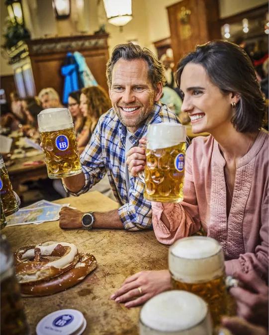 Hofbräu Original Pärchen mit Masskrügen anprosten