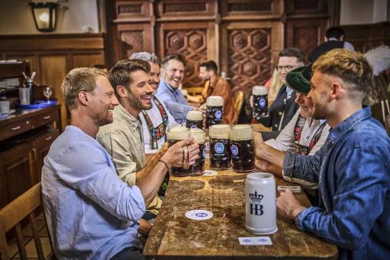 group of men in a bavarian tavern with dark beer mugs