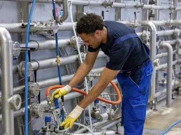 Mitarbeiter in der Brauerei an der Arbeit im Overall