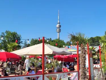 S-Beach Bar mit Sonnenschirmen und Olympiaturm im Hintergrund