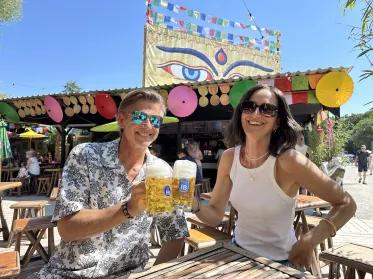 Anstoßszene mit Hofbräu Masskrügen im Buddha Garten