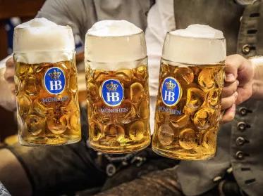 Masskrüge mit Tracht im Hintergrund