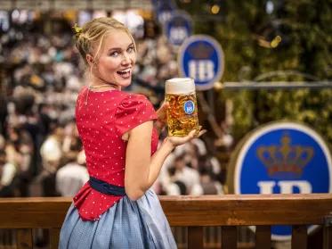 Frau im Dirndl mit Masskrug auf Hofbräu-Zelt Balkon