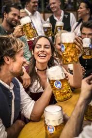 Wiesn Freundesgruppe am Biertisch im Festzelt mit Masskrügen